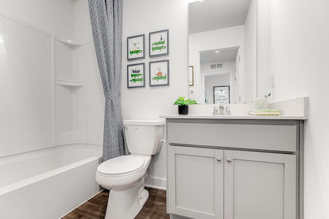 full bathroom featuring vanity, hardwood / wood-style floors, shower / tub combo, and toilet