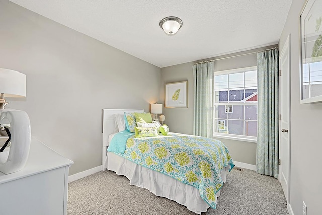 bedroom featuring light carpet and a textured ceiling