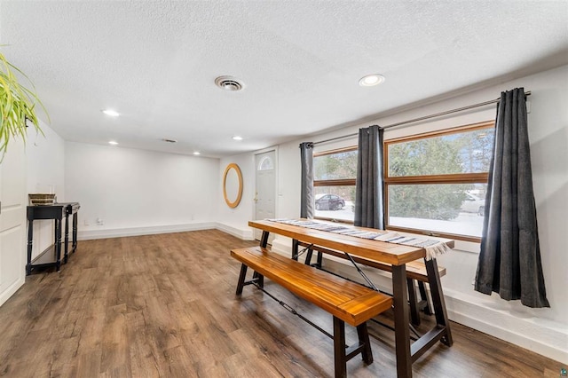 dining space featuring hardwood / wood-style floors and a textured ceiling