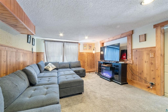 carpeted living room featuring a textured ceiling and wood walls