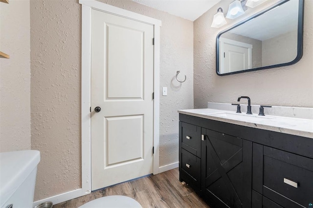 bathroom with vanity, hardwood / wood-style floors, and toilet