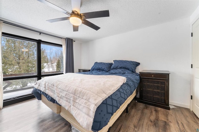 bedroom featuring ceiling fan, dark wood-type flooring, and a textured ceiling