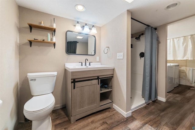 bathroom with wood-type flooring, washer / dryer, vanity, toilet, and a shower with shower curtain