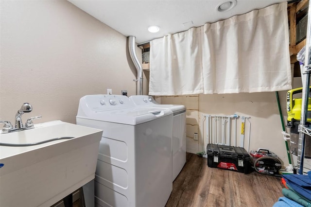 laundry area featuring dark wood-type flooring, sink, and washing machine and clothes dryer