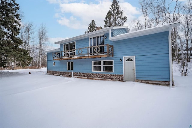 snow covered house with a wooden deck