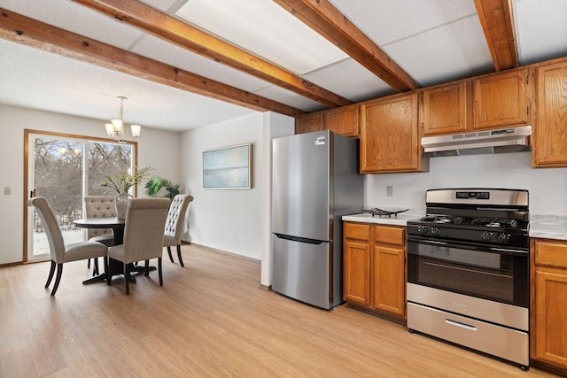 kitchen with appliances with stainless steel finishes, decorative light fixtures, beamed ceiling, a notable chandelier, and light wood-type flooring