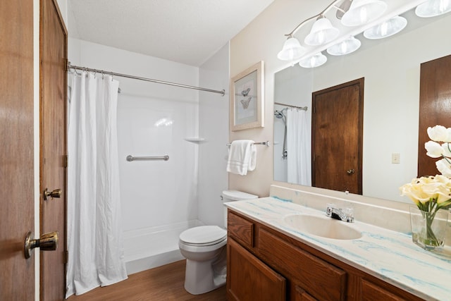 bathroom featuring vanity, wood-type flooring, a textured ceiling, a shower with curtain, and toilet