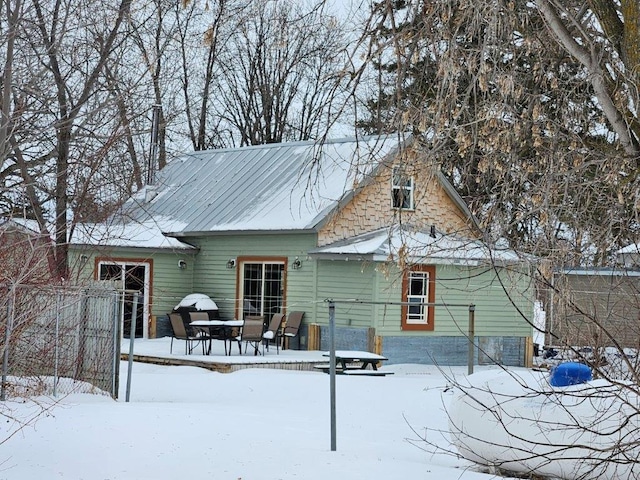 view of snow covered rear of property