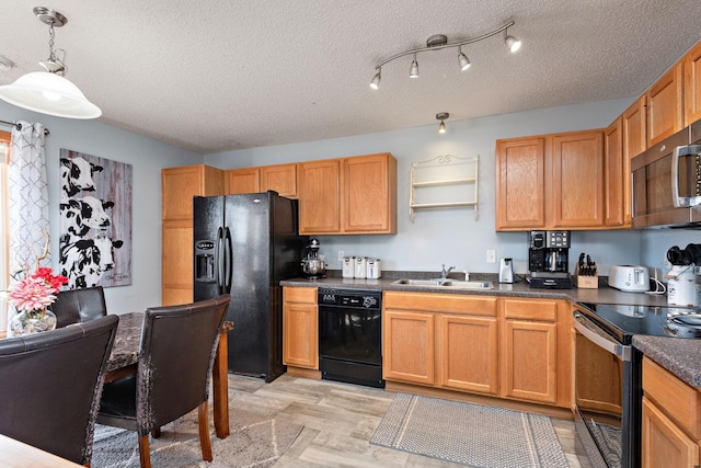 kitchen featuring sink, light hardwood / wood-style flooring, hanging light fixtures, black appliances, and a textured ceiling