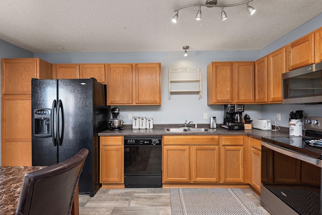 kitchen featuring light hardwood / wood-style floors, sink, a textured ceiling, and black appliances