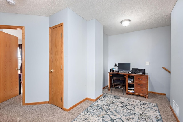 office featuring light colored carpet and a textured ceiling