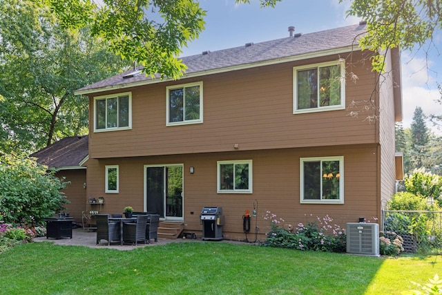 back of house with central AC and a lawn