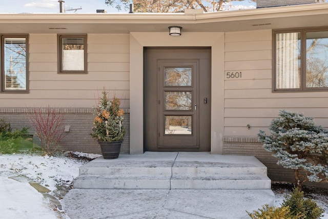 view of snow covered property entrance