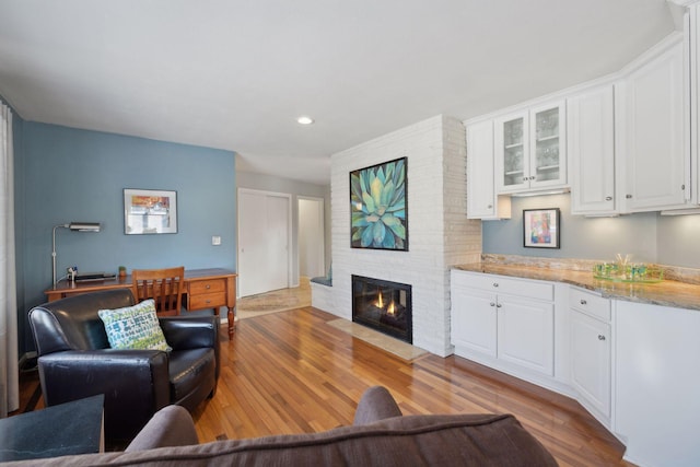 living room featuring hardwood / wood-style flooring and a brick fireplace