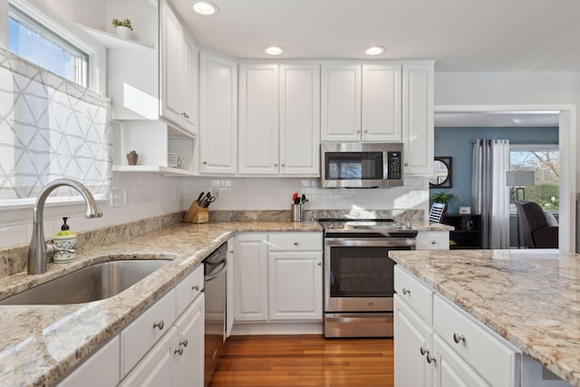 kitchen featuring light stone counters, sink, white cabinets, and appliances with stainless steel finishes