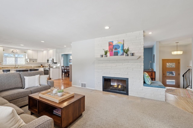 carpeted living room with sink and a fireplace