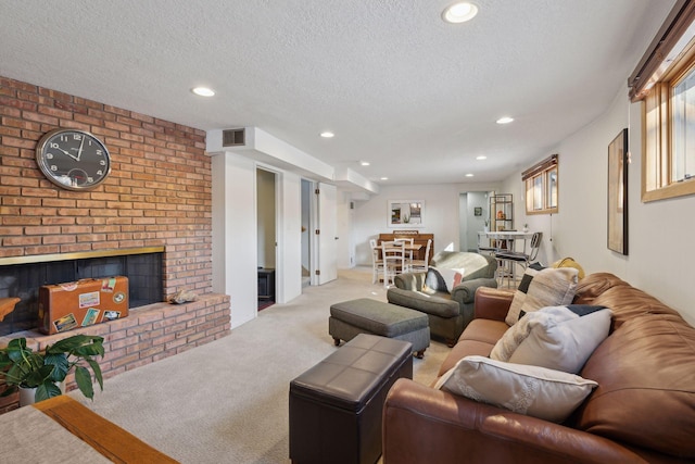 living room featuring a brick fireplace, light carpet, and a textured ceiling