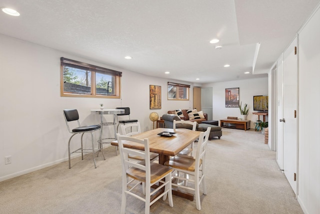 carpeted dining area featuring a textured ceiling