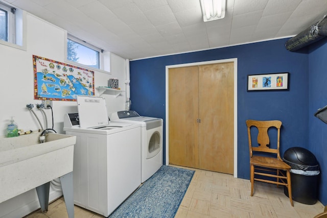 laundry area featuring sink, independent washer and dryer, and light parquet flooring