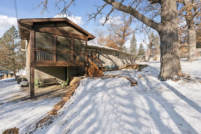 snow covered house with a sunroom