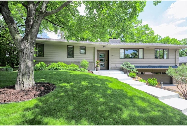 view of front of property with a garage and a front lawn