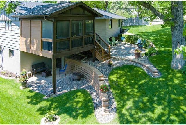 back of house featuring a sunroom, a yard, and a patio area