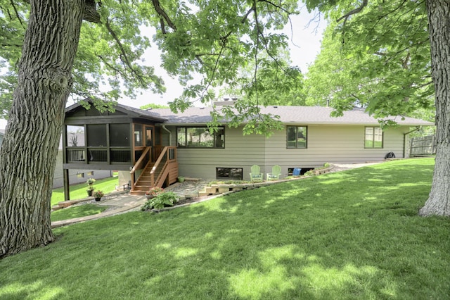 back of property with a yard, stairs, and a sunroom