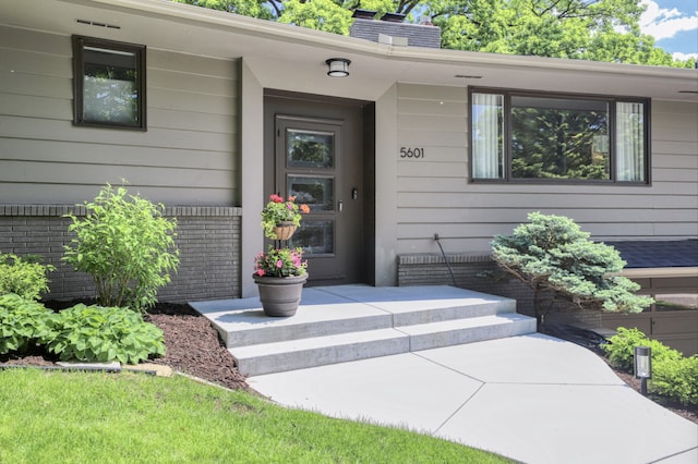 doorway to property featuring brick siding