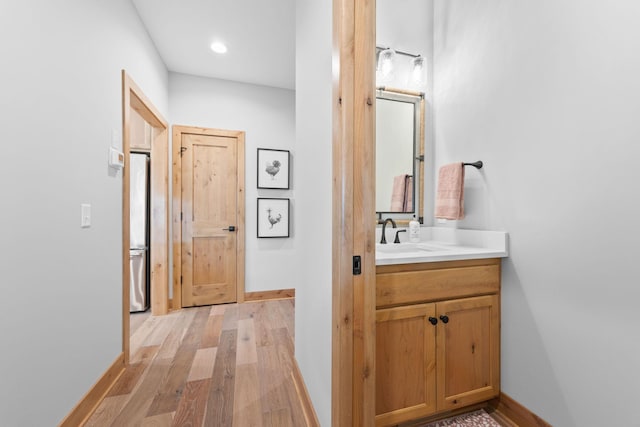 corridor featuring sink and light hardwood / wood-style floors