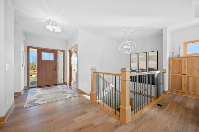 foyer entrance featuring hardwood / wood-style flooring and a chandelier