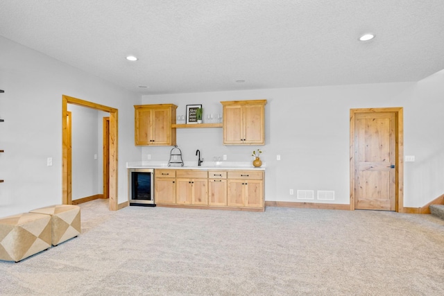 kitchen featuring wine cooler, light colored carpet, and light brown cabinets