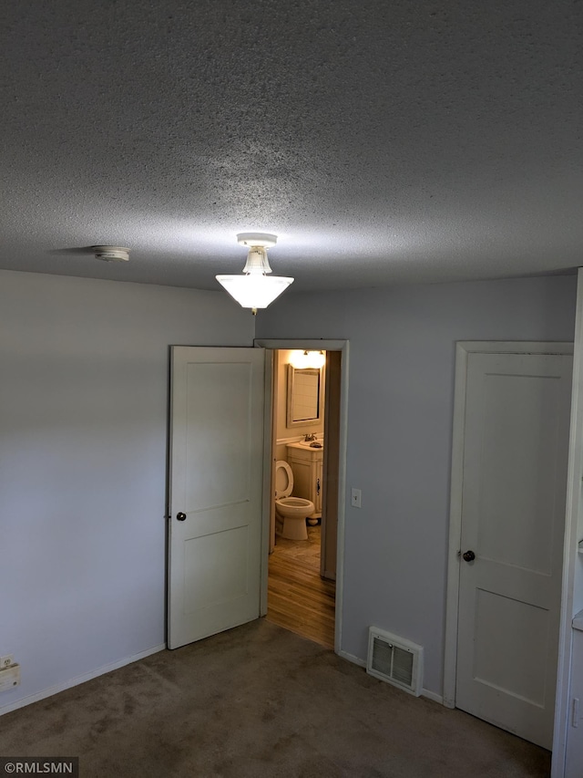 unfurnished bedroom featuring carpet and a textured ceiling