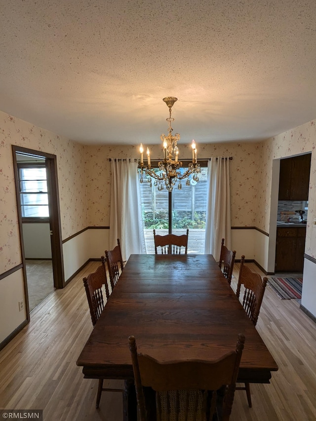 dining area with hardwood / wood-style flooring, plenty of natural light, and a textured ceiling