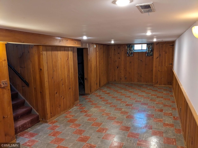 basement featuring wood walls