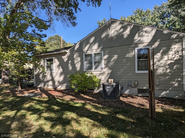 view of side of home featuring a yard and central air condition unit