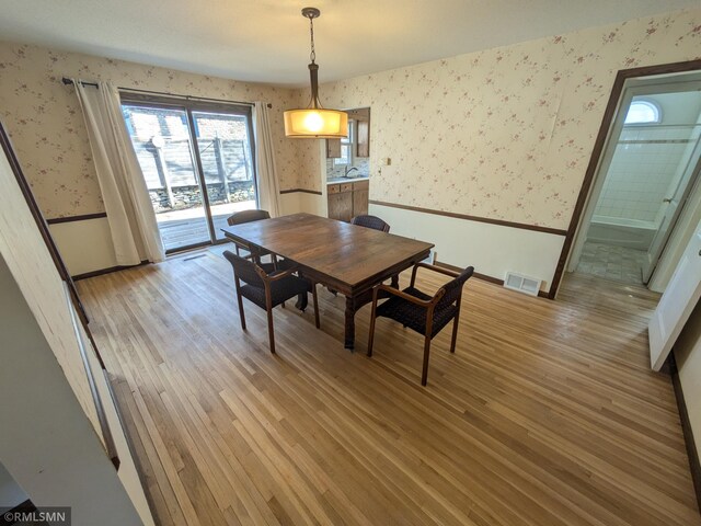 3501 Virginia Ave S, Saint Louis Park, MN 55426 - dining space with wallpapered walls, light wood finished floors, and baseboards