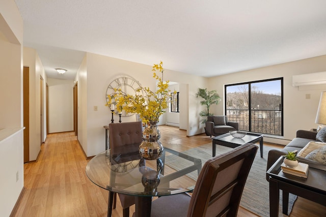 dining area featuring an AC wall unit, a baseboard heating unit, and light hardwood / wood-style floors