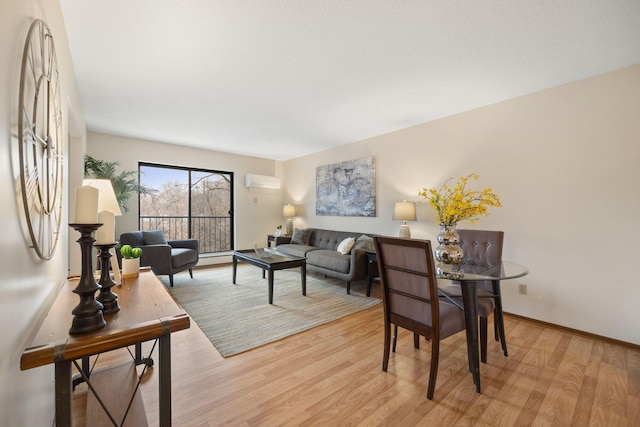 living room featuring an AC wall unit and light wood-type flooring