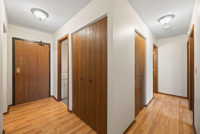 hall featuring a textured ceiling and light wood-type flooring