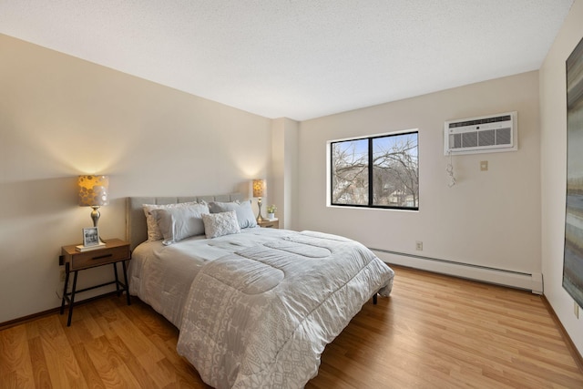 bedroom with a baseboard radiator, a wall mounted AC, a textured ceiling, and light wood-type flooring