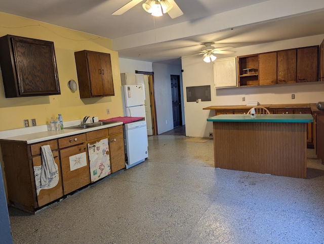 kitchen featuring a kitchen island, sink, dark brown cabinetry, ceiling fan, and white appliances