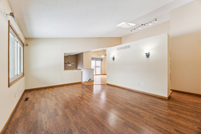 unfurnished living room featuring vaulted ceiling, a textured ceiling, wood finished floors, and visible vents