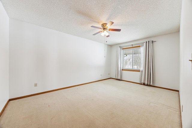 unfurnished room featuring ceiling fan, baseboards, a textured ceiling, and light colored carpet