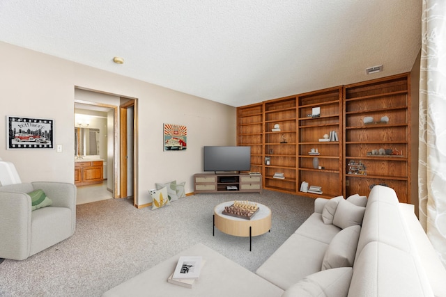 living area featuring a textured ceiling, carpet flooring, and visible vents