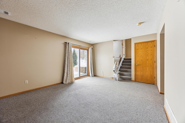 unfurnished room featuring a textured ceiling, carpet flooring, visible vents, baseboards, and stairway