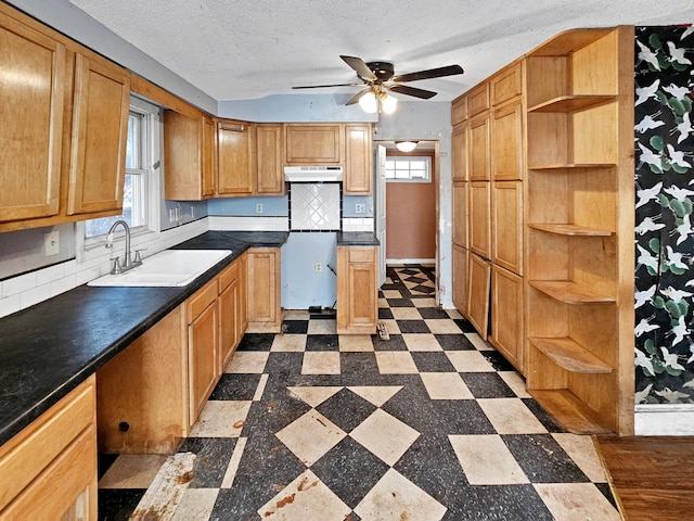 kitchen with refrigerator, sink, a textured ceiling, and backsplash