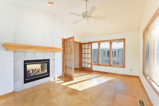 unfurnished living room with a tile fireplace, high vaulted ceiling, and ceiling fan