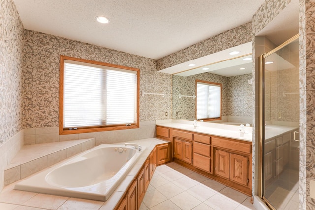 bathroom with a wealth of natural light, vanity, a textured ceiling, and tile patterned flooring