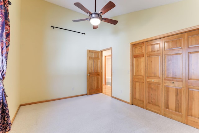 unfurnished bedroom with ceiling fan and light colored carpet