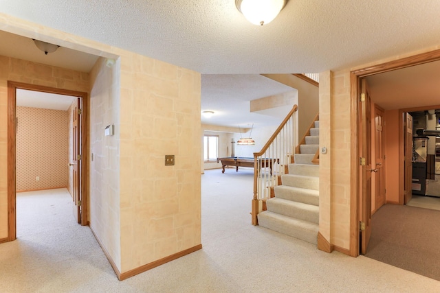 hallway featuring carpet floors and a textured ceiling